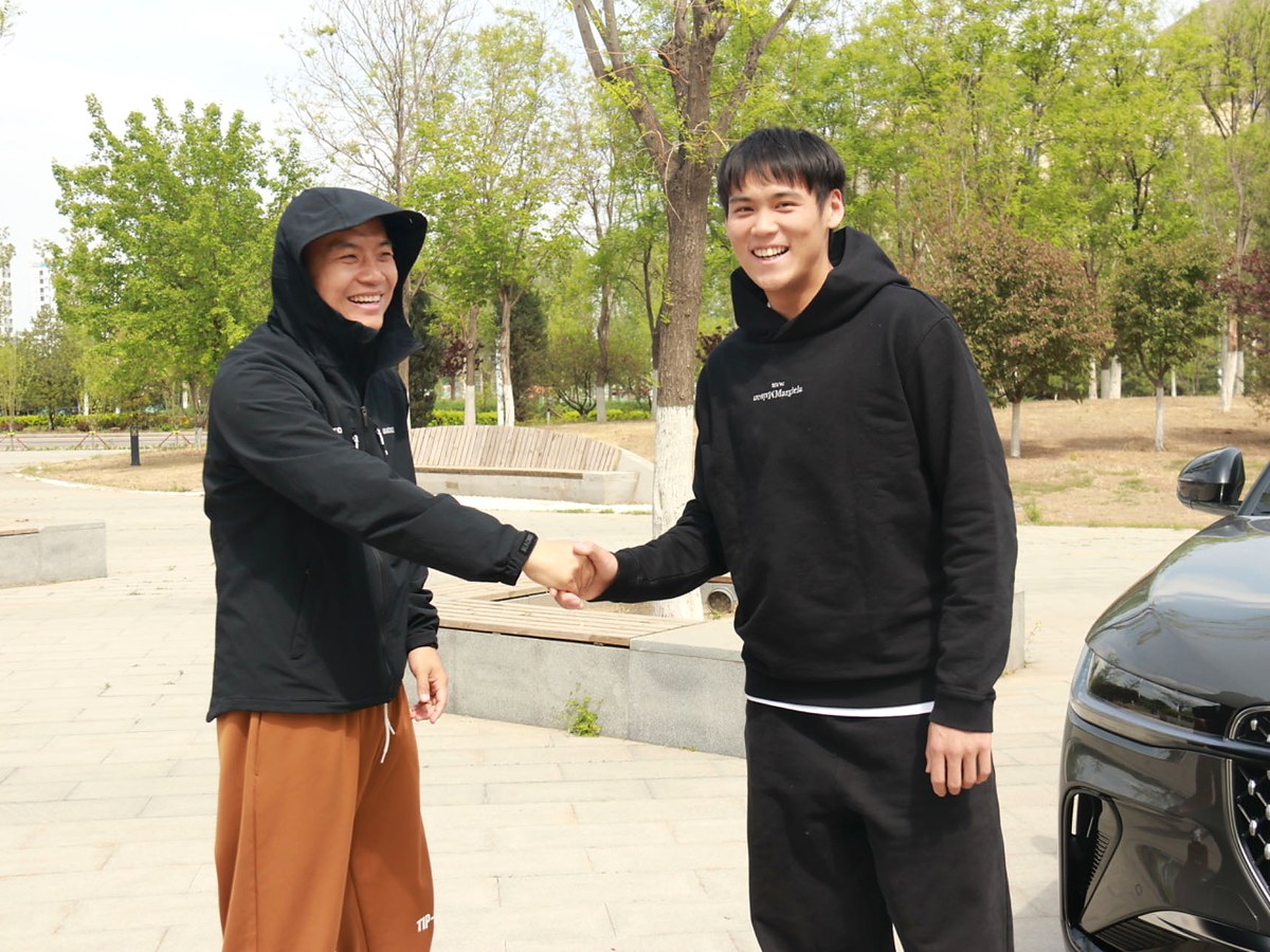 Adam Zhang shaking hands with the director on the Lincoln Nautilus shoot